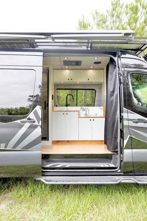 Open side door of a completed War Horse custom van showing its interior